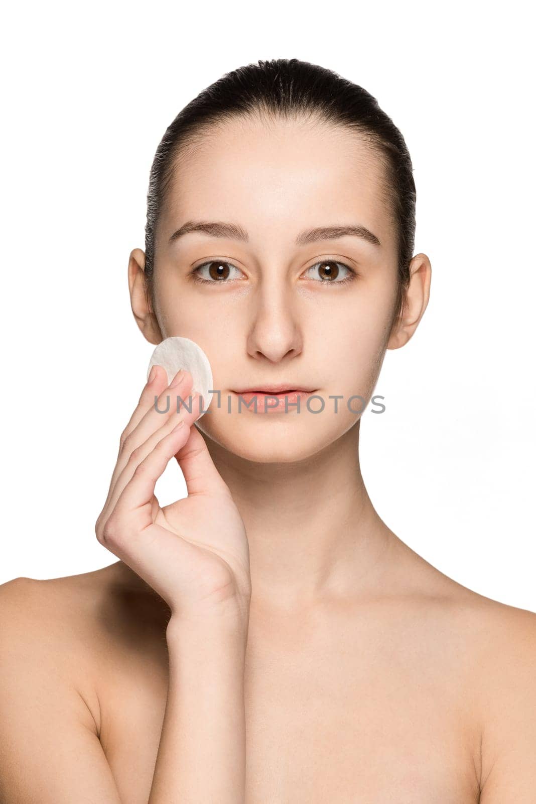 skin care woman removing face with cotton swab pad - skin care concept. Facial closeup of beautiful Caucasian model with perfect skin. Girl isolated on white background