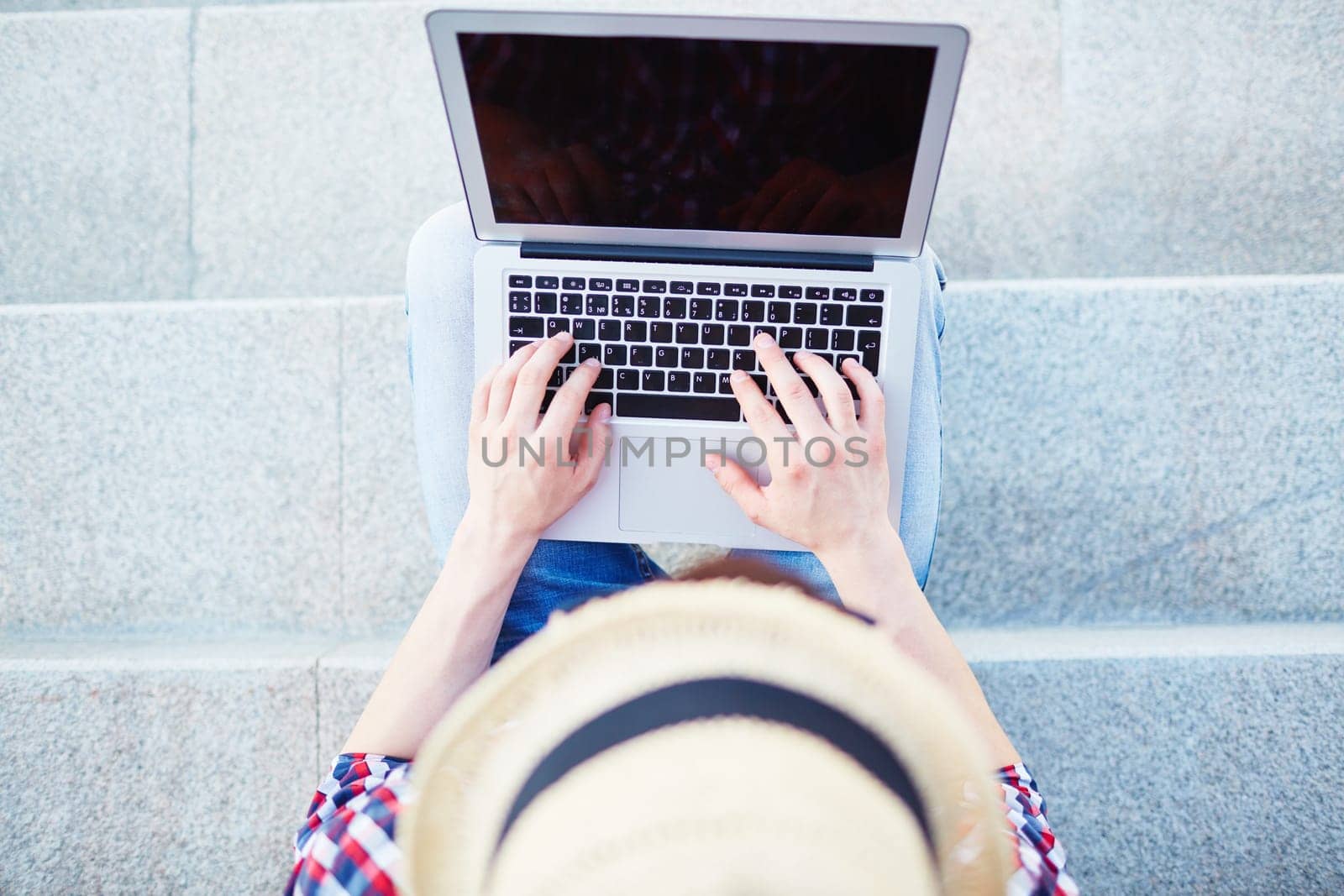 Modern guy typing on laptop outdoors