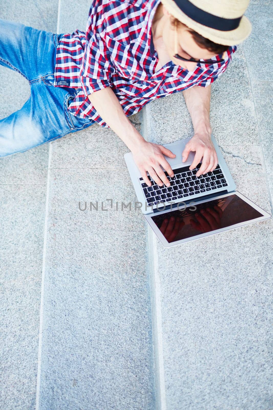 Modern guy networking on stairs outdoors