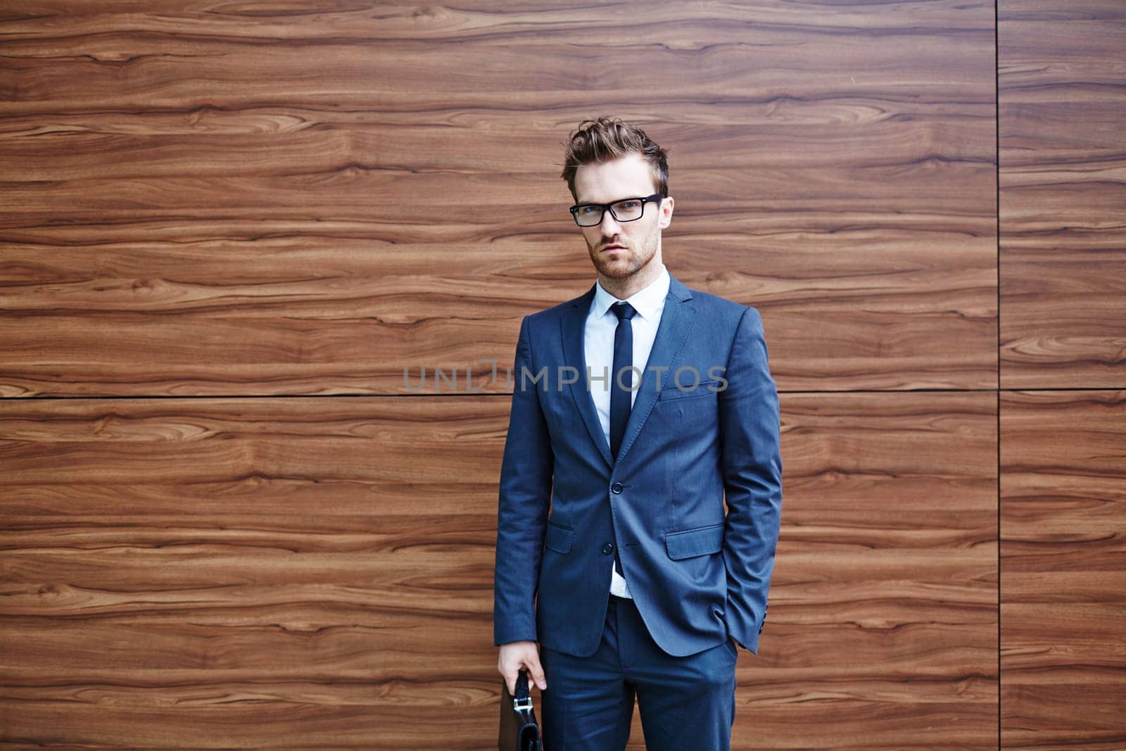 Serious businessman in suit looking at camera outside