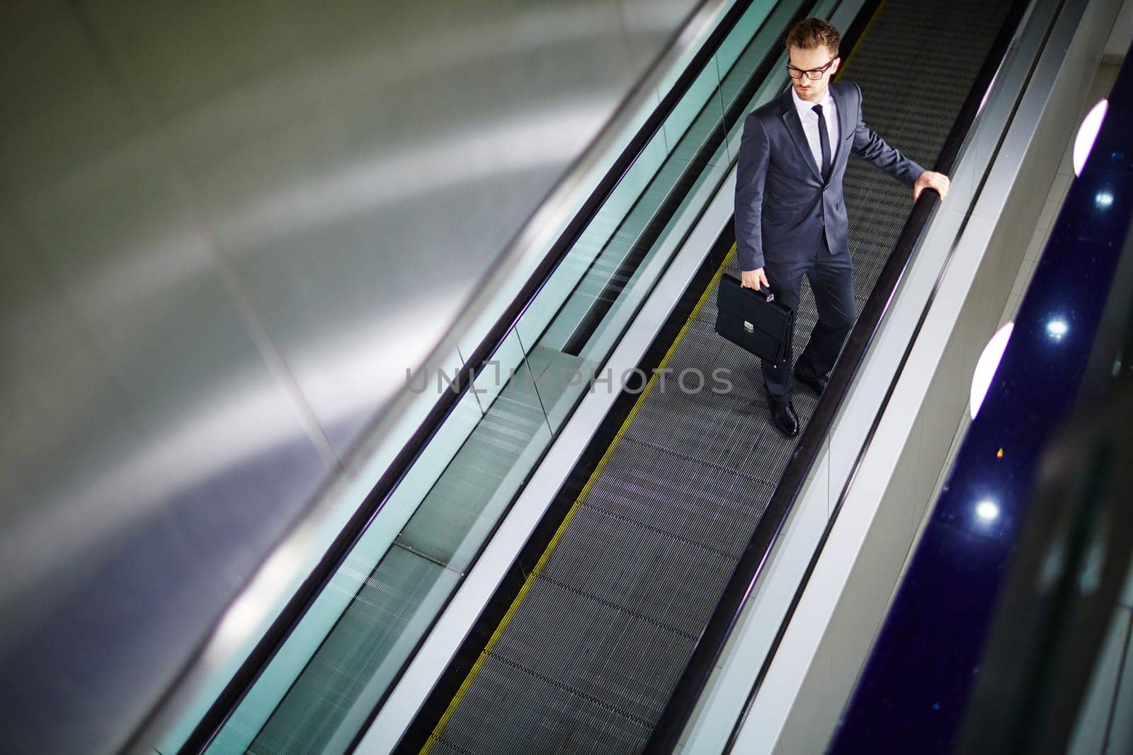 Attractive businessman moving on escalator