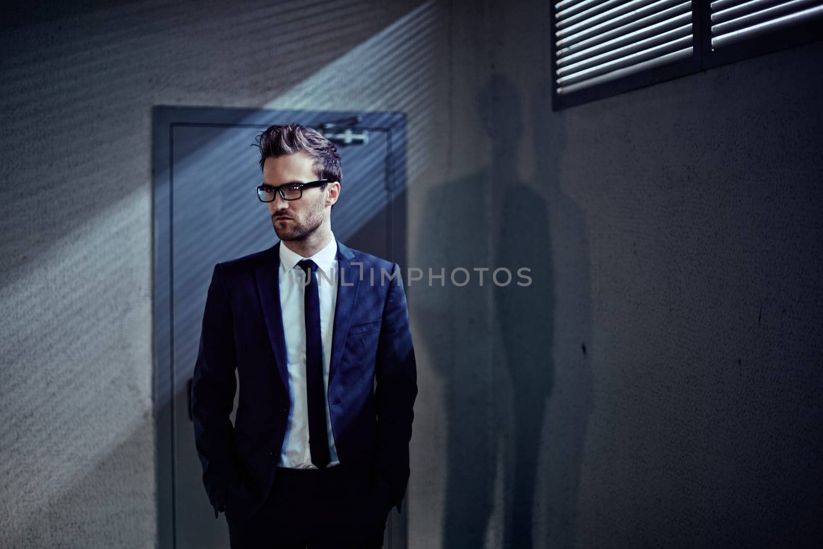Elegant young businessman standing by the door inside office building
