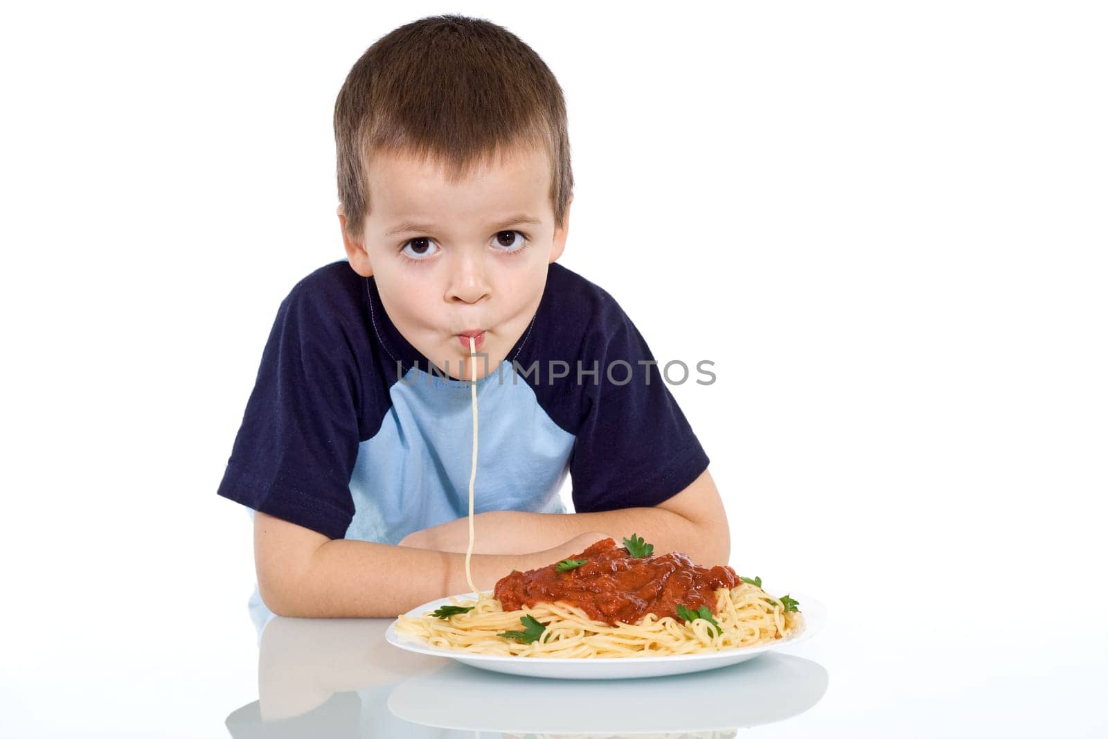 Boy eating pasta - sipping it up - isolated
