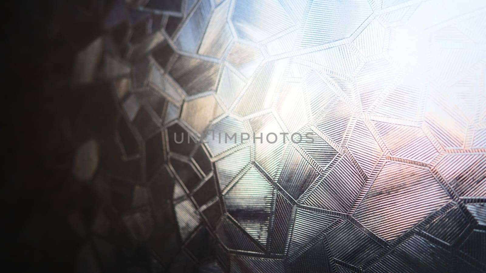 Fluted glass with backlight. Beautiful multicolored refraction of light. Abstract background. Self-adhesive film. Ribbed glass surface. Embossed glass background.
