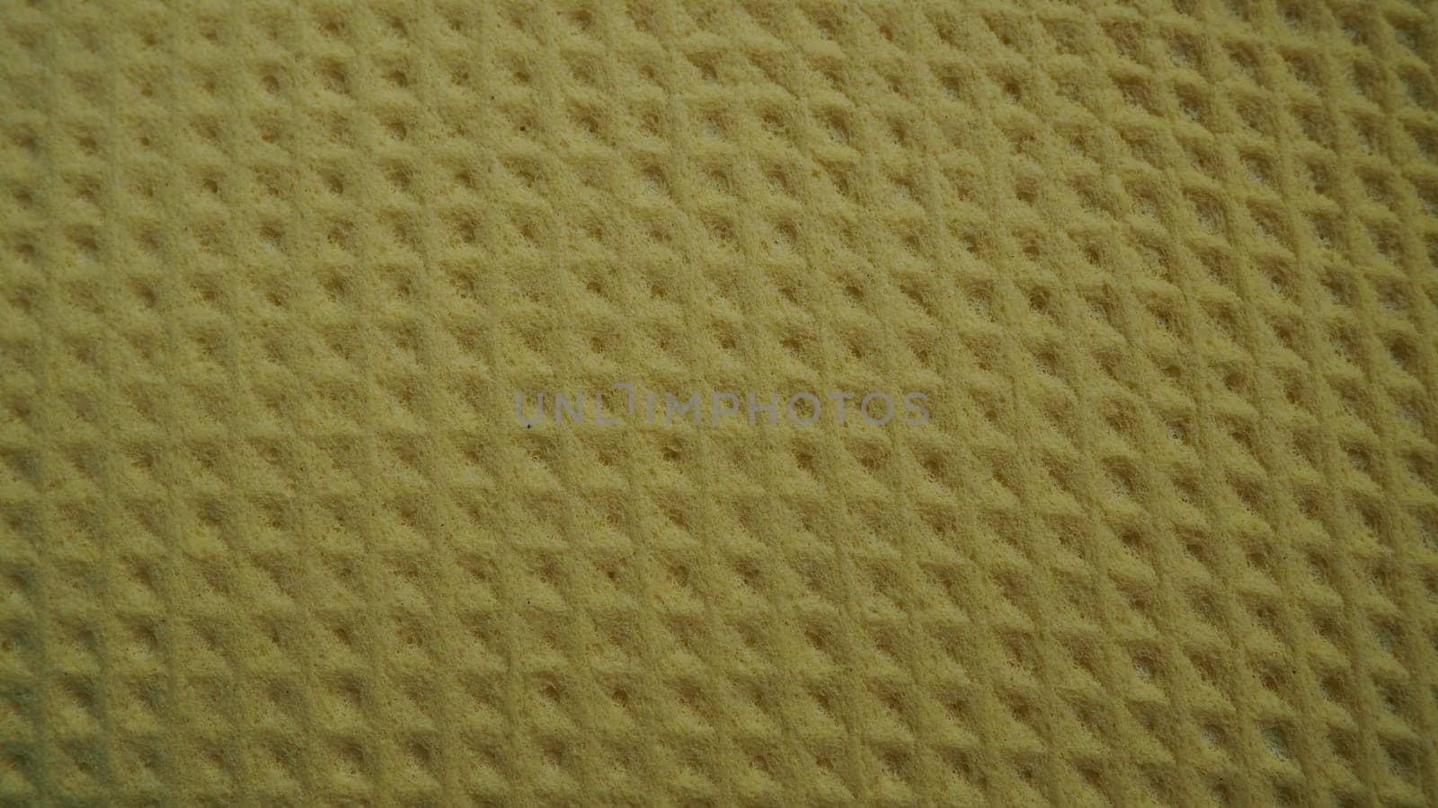 Sponge fibers sponge texture pattern surface close-up yellow brown background.