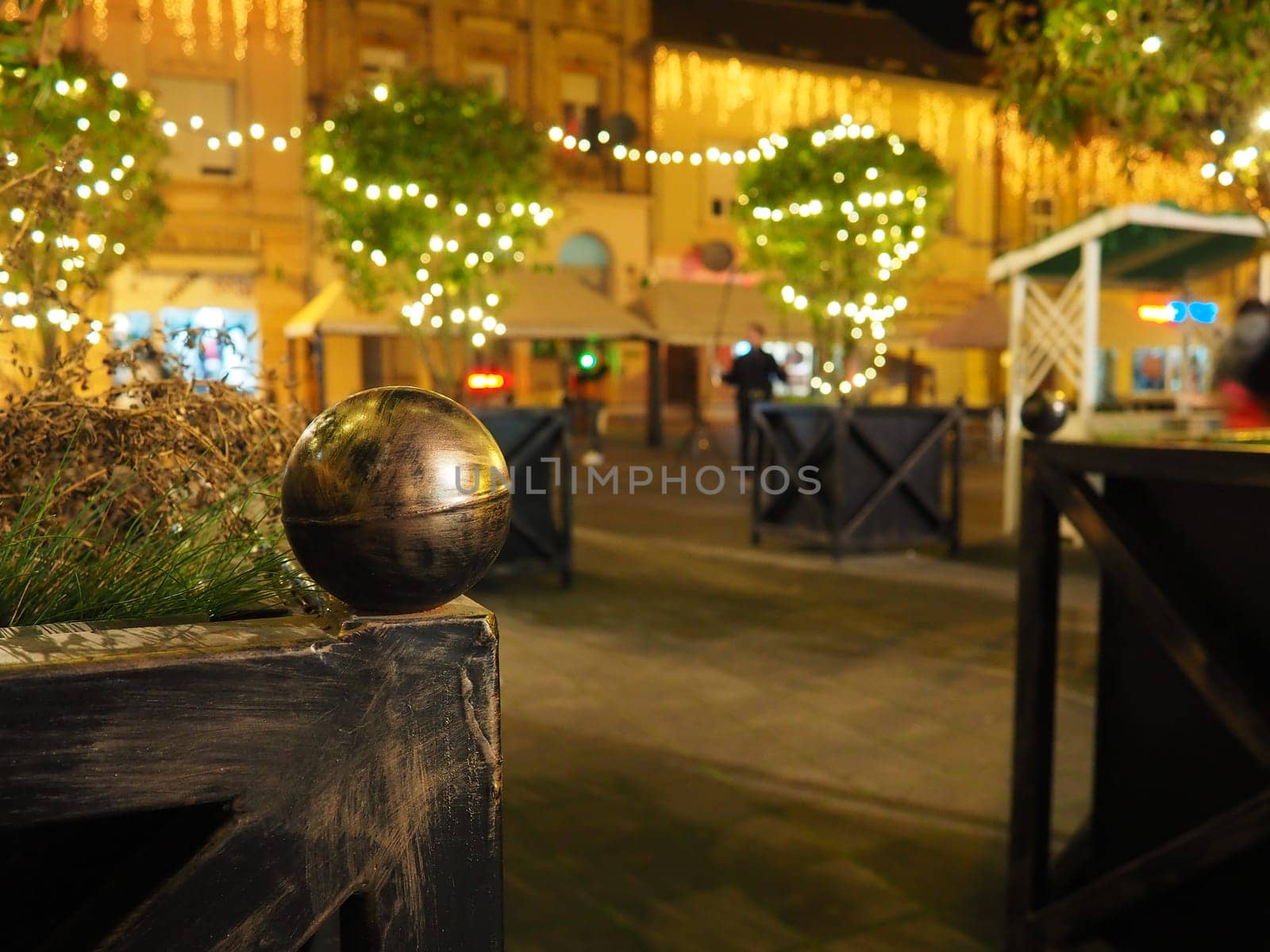 Hanging garlands against the background of the night sky. Festive decoration of city streets. Garlands of yellow, white and gold lights and bulbs. Beautiful background for New Year, Christmas holiday