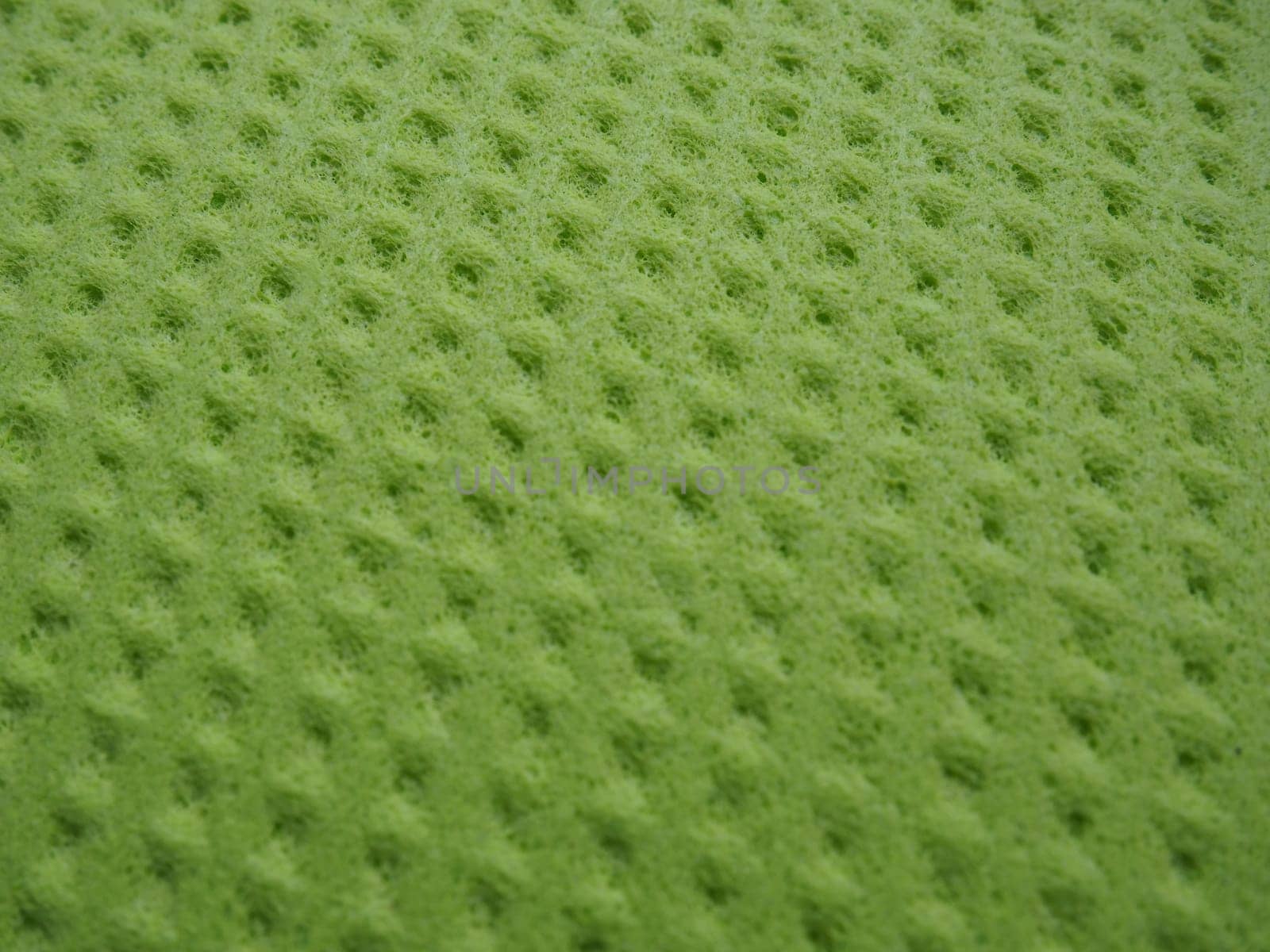 Sponge fibers sponge texture pattern surface close-up green yellow background.