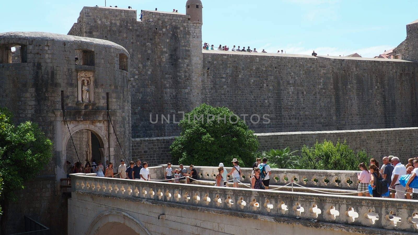 Pile Gate Dubrovnik Croatia August 14 2022 People men and women walk along the stone bridge to the gate of the Old City. Crowd of tourists. Busy entrance. The main entrance to Old Town, busy Pile Gate