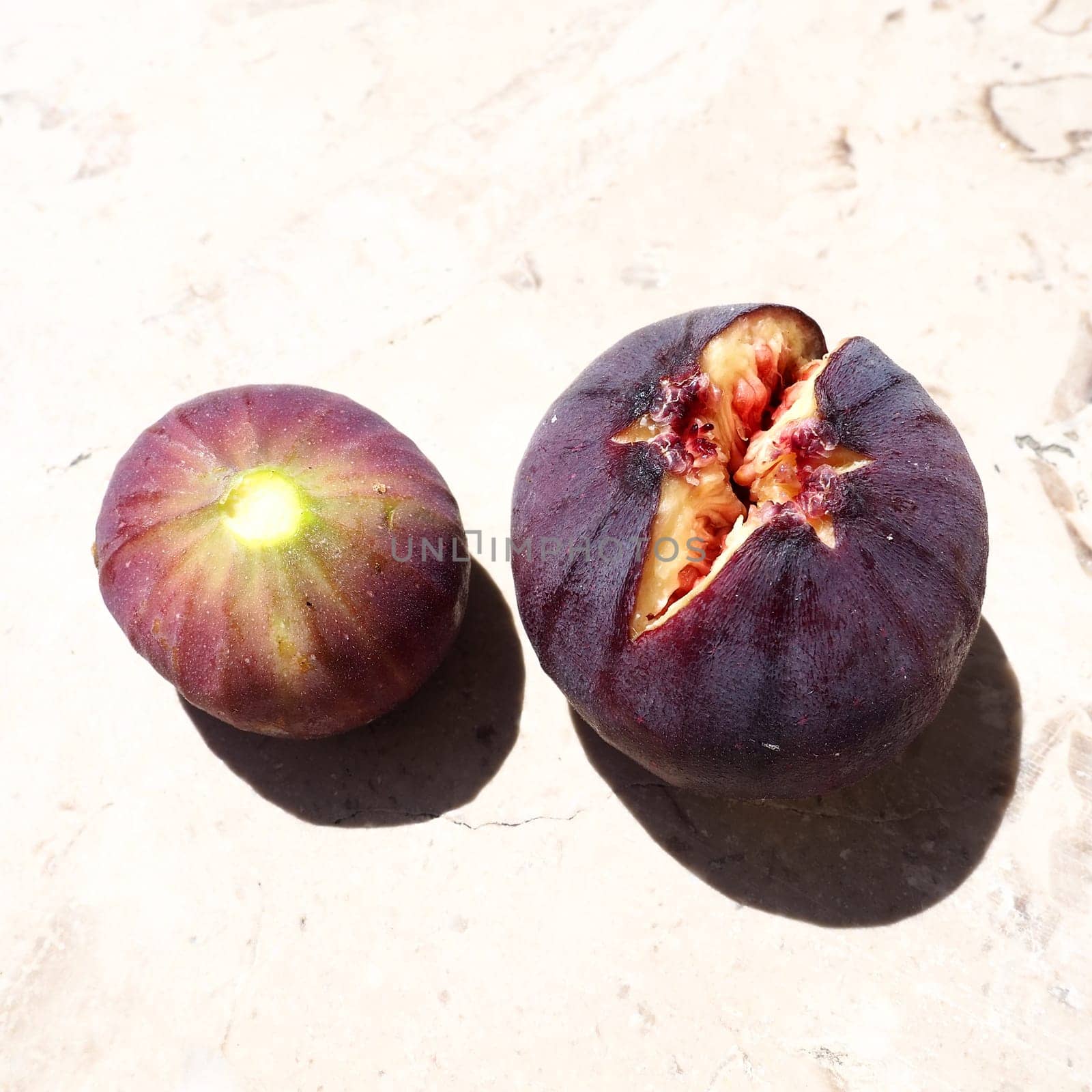 Fig or fig tree, or common fig tree, or Ficus carica is a subtropical deciduous plant of the genus Ficus of the Mulberry family. Ripe purple fig fruits on a light background. Healthy food.