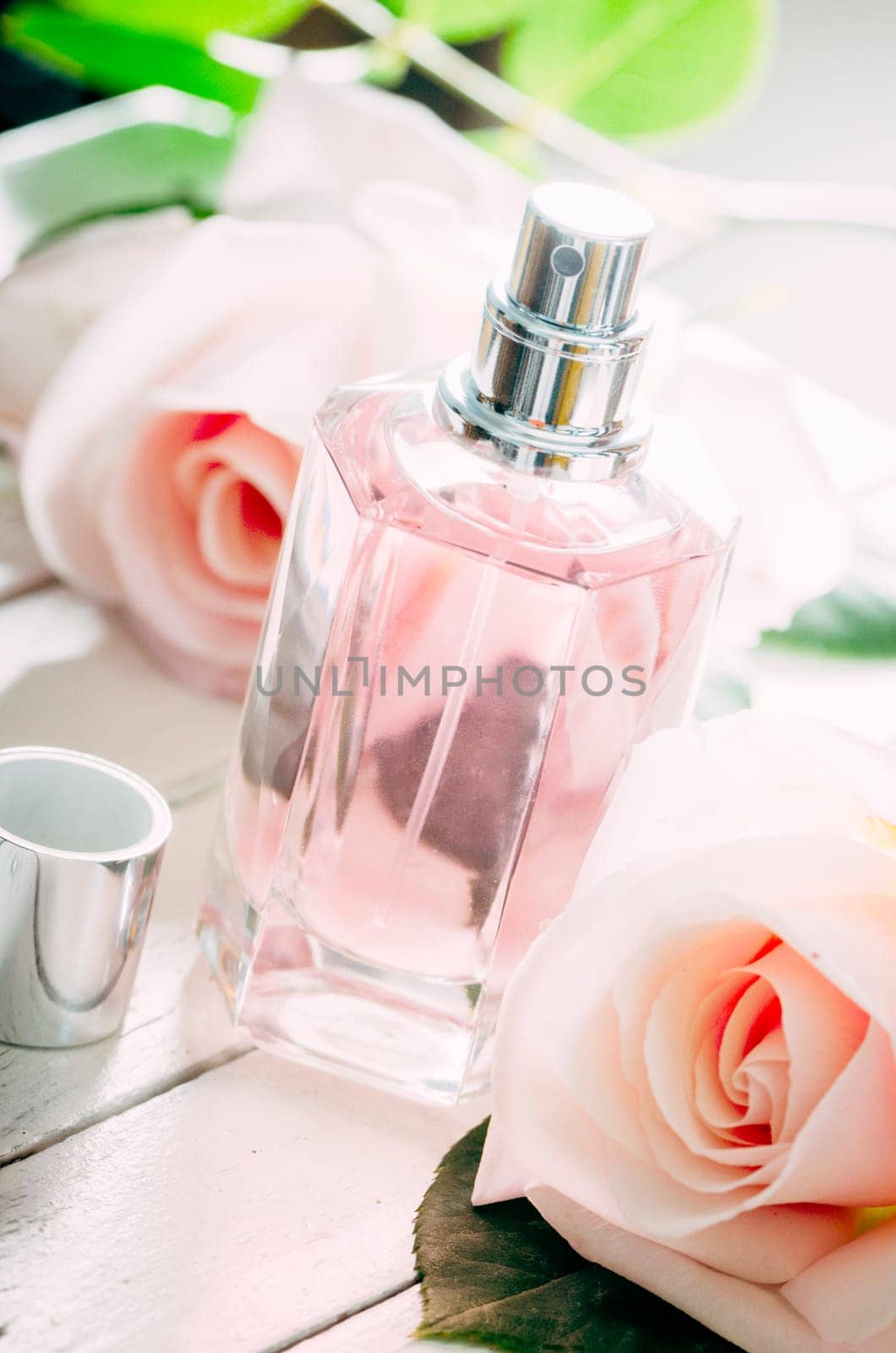 Bottle of perfume and pink wedding roses bouquet decoration.