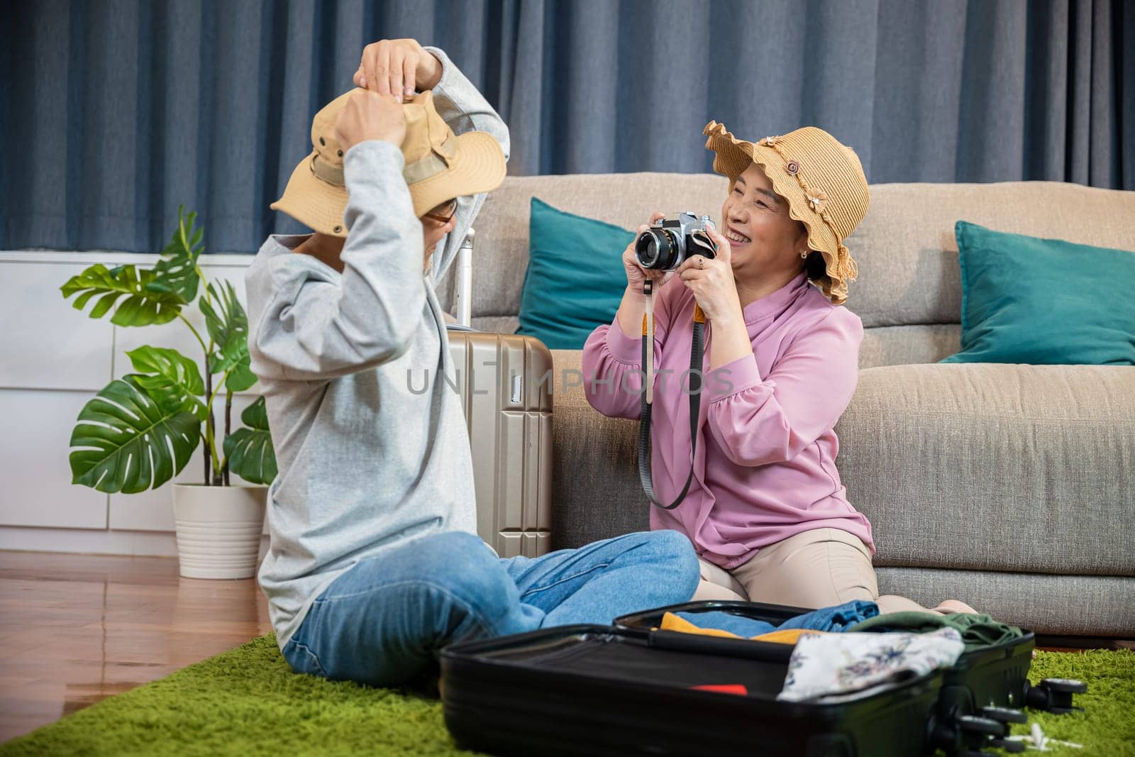 Travel and tourism. Asian couple old senior marry retired couple smiling taking photo by camera during luggage suitcase arranging for travel, Happy mature retired couple photography weekend holiday