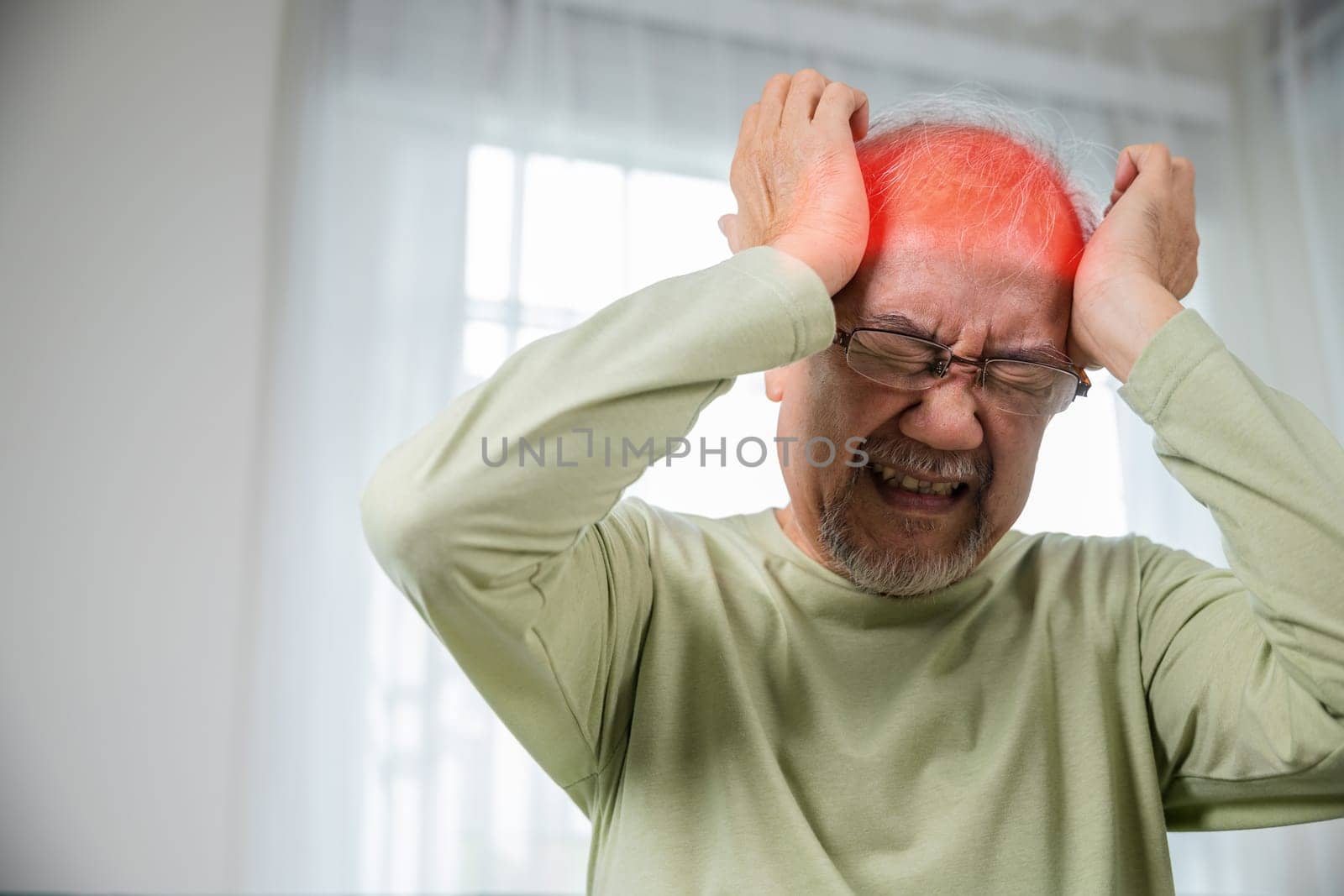 Headache. Sad Asian senior man chronic migraine pain massaging, old man holds head with hand for headache disease in living room at home, Old age health problems, healthcare