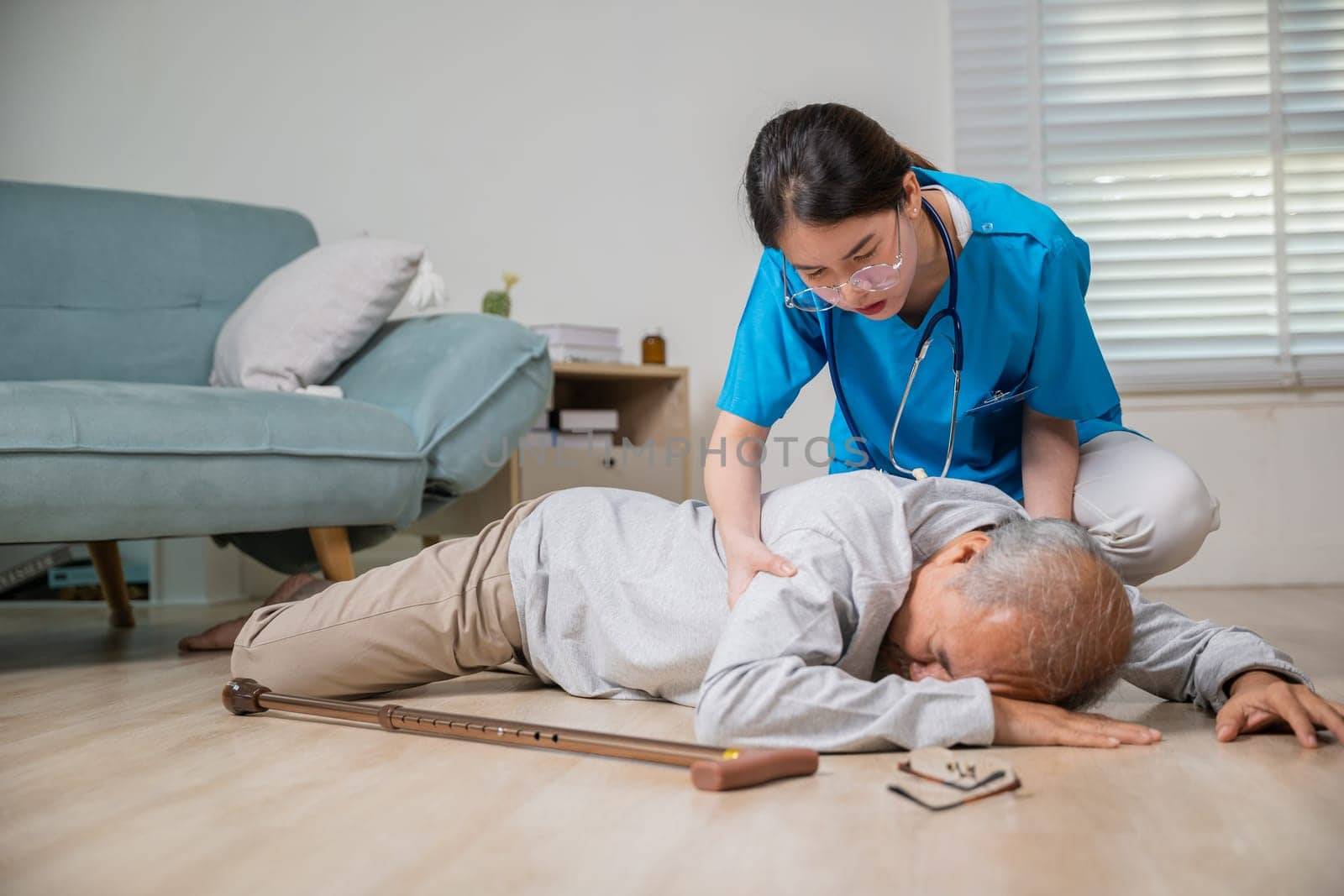 Disabled elderly old man patient with walking stick fall on floor and caring young assistant at nursing home, Asian older senior man falling down on lying floor and woman nurse came to help support