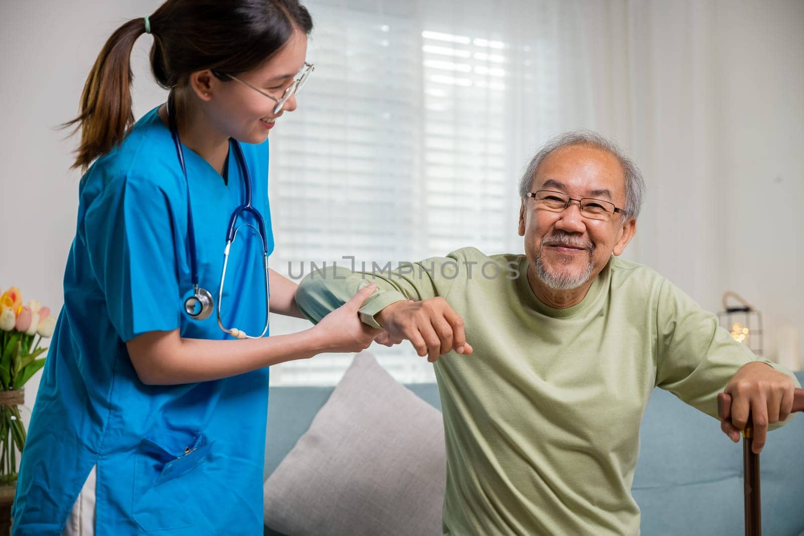 Young woman help support orthopedic patients to get up with walking cane at home, Caring nurse helping supporting senior disabled man to stand up with walking stick, International Day for the Elderly