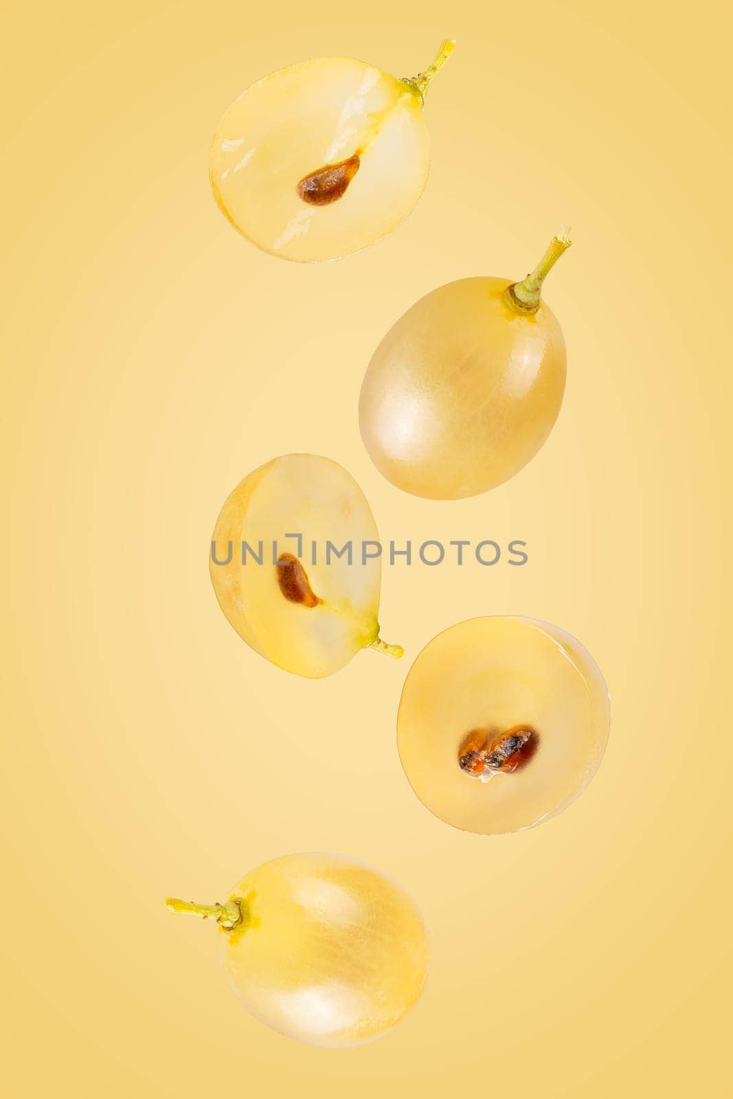 Isolated flying grapes. Five whole and sliced grape fruits falling on white with clipping path as package design element and advertising. Full depth of field.