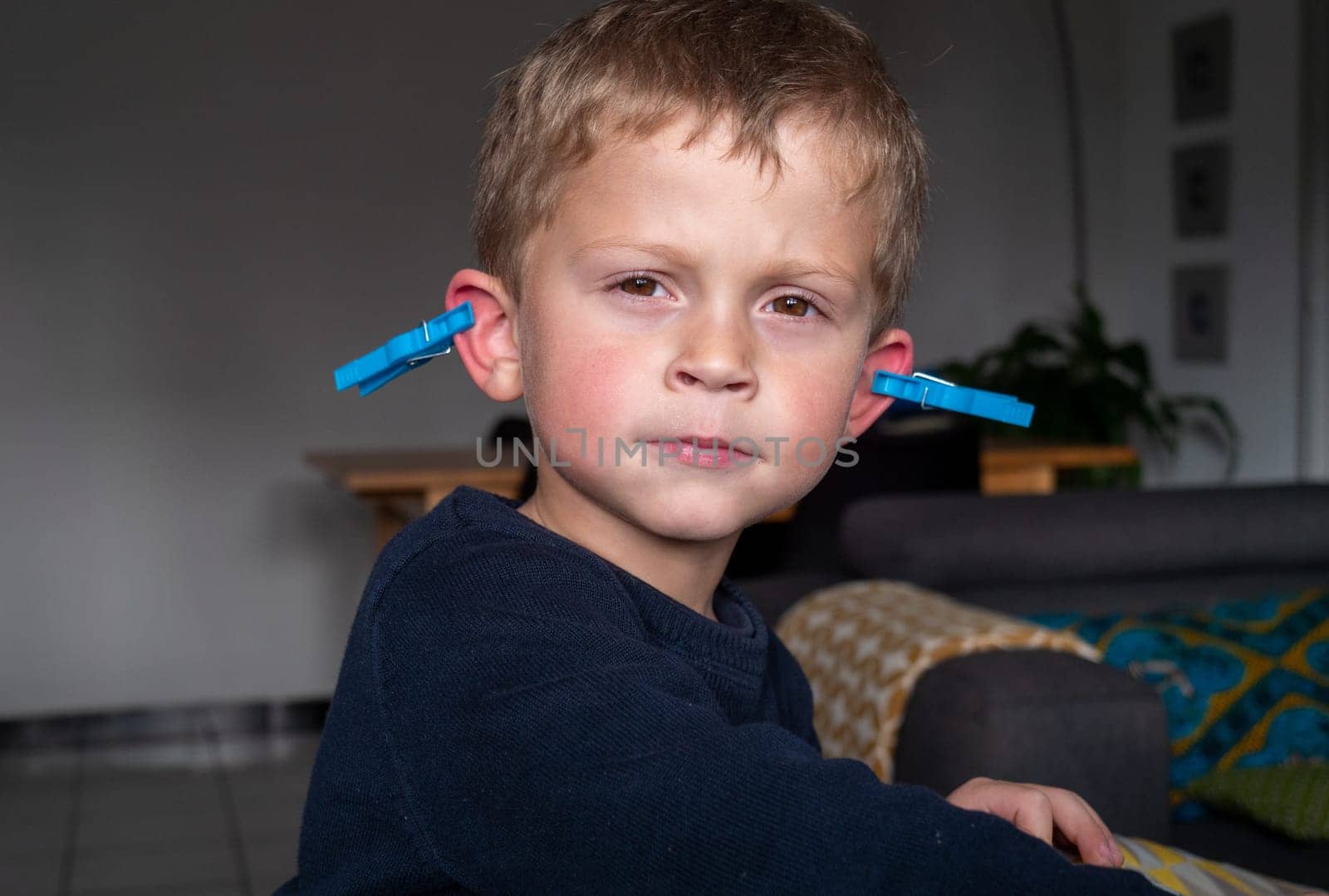 a funny boy with clothes pegs on the ears