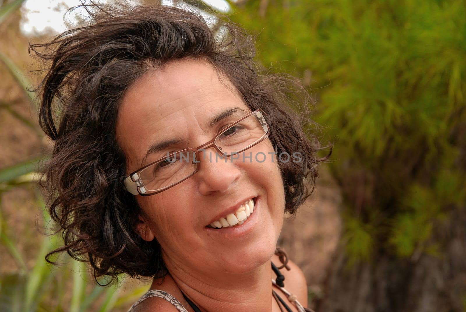 a portrait of beautiful brunette mature woman with eyeglasses