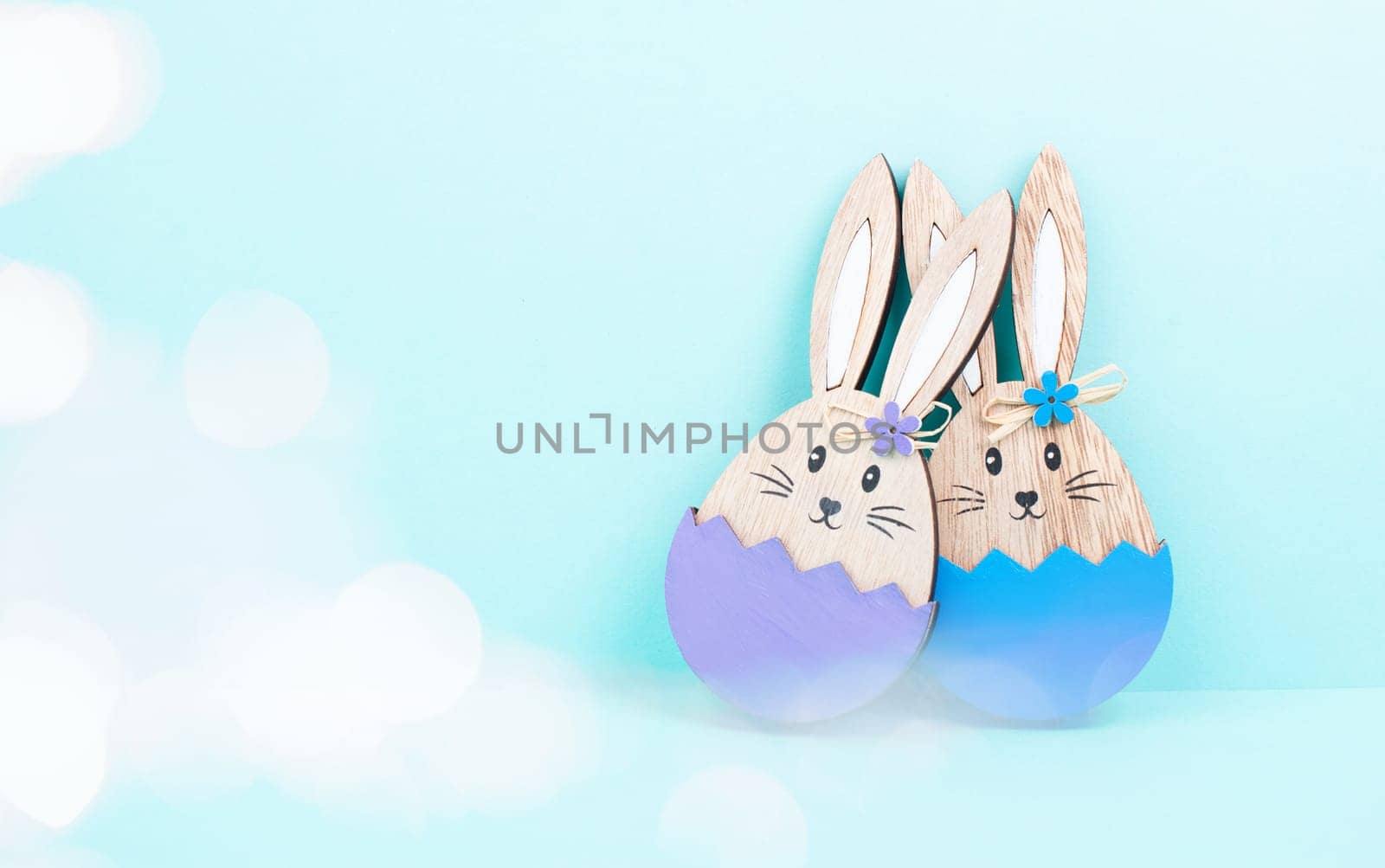 Easter bunny or rabbit couple cuddle together, wooden egg, spring holiday greeting card, bokeh fairy light, blue and purple color