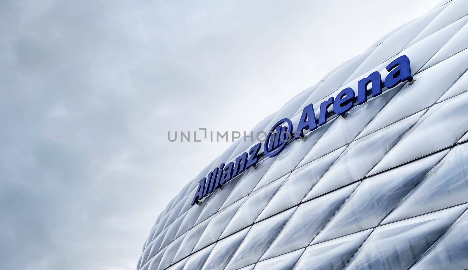 Munich, DE, Dec 2022: view of the exterior of the Allianz Arena in Munich on a cloudy day. The membrane covering the stadium illuminates in different colors depending on the event taking place inside.