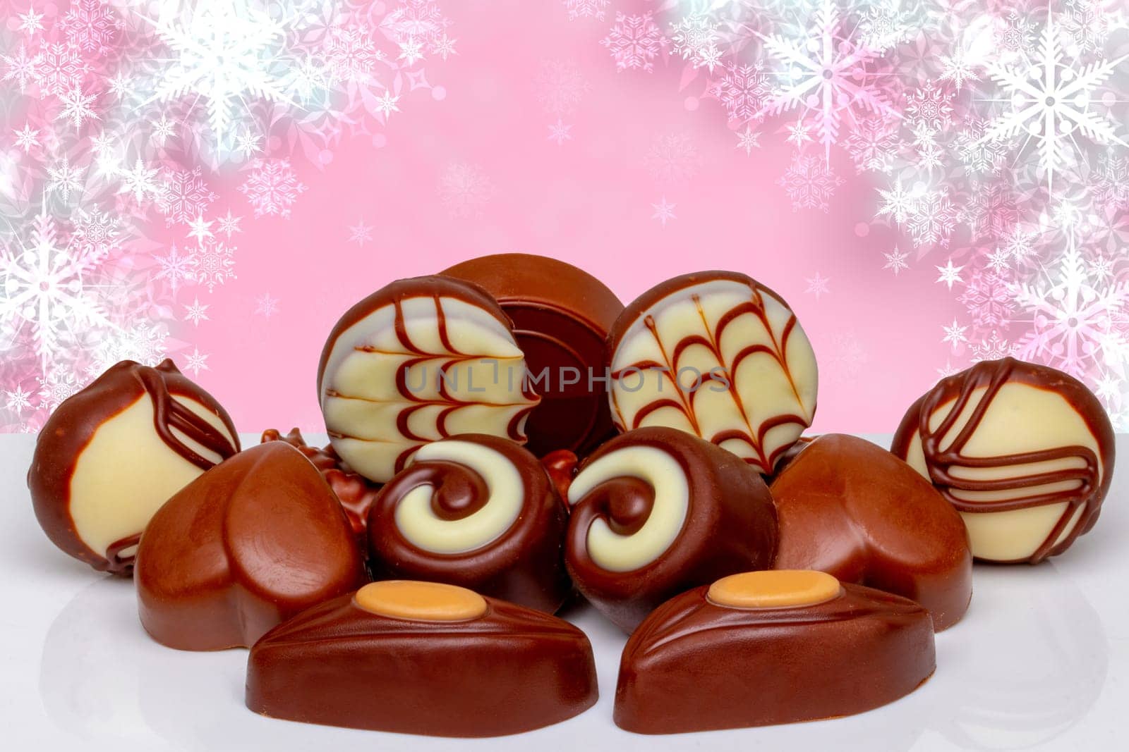 Chocolate candy collection. Beautiful assortment of expensive Swiss chocolate truffles and praline sweets on table over abstract festive background. Copy space.