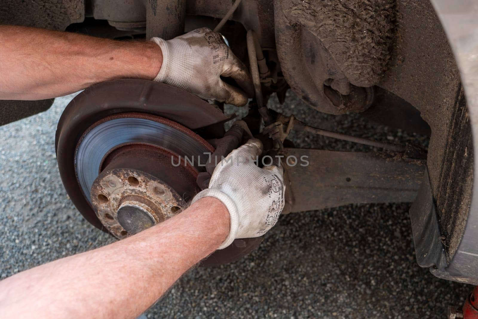 a car mechanic repairing brakes on car