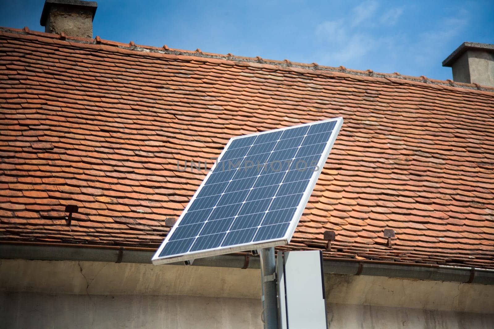Installed solar panels in the street. Red roof behind.