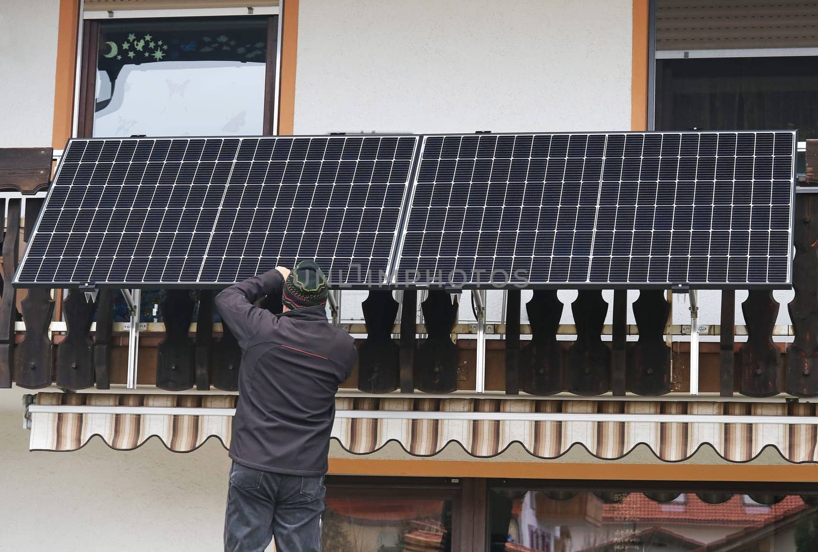 A man assembles a balcony power plant to generate electricity
