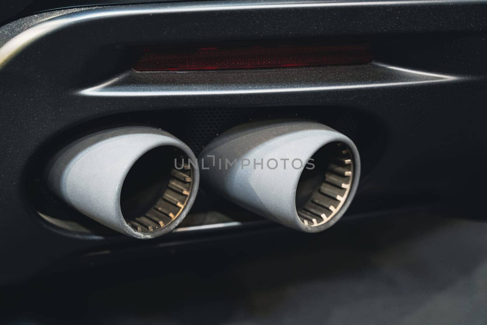 detail rear view of black sport car pair of exhaust pipes