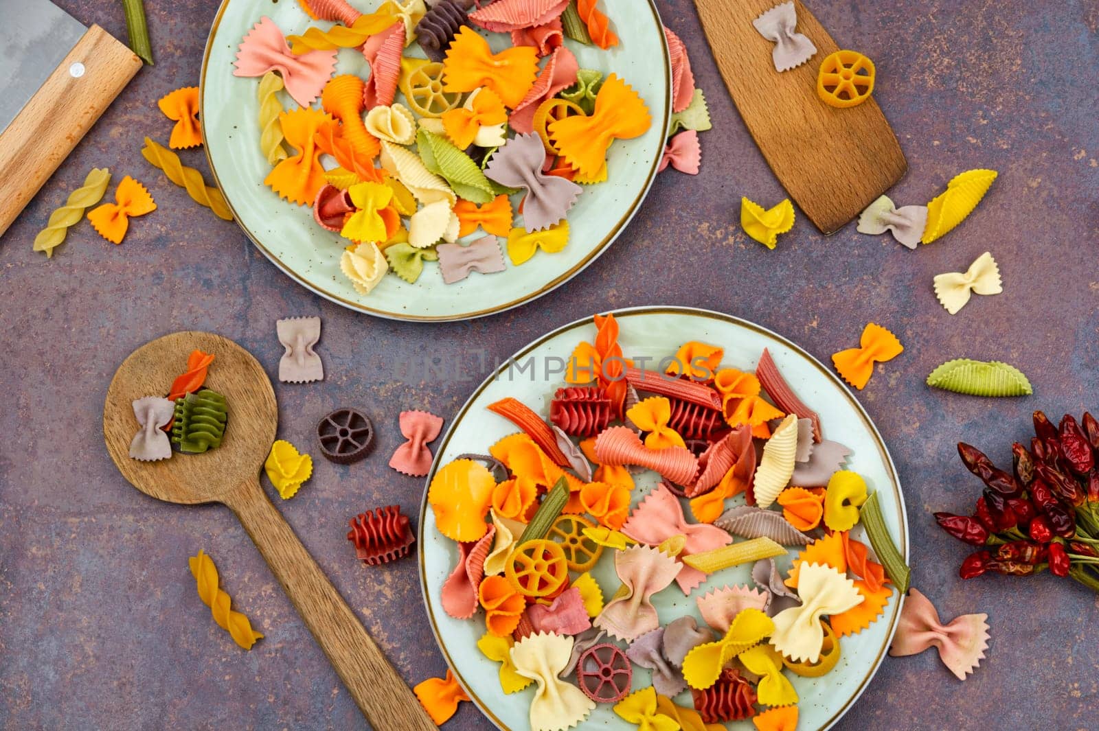 Colorful italian raw pasta on plate. Heap of colorful macaroni