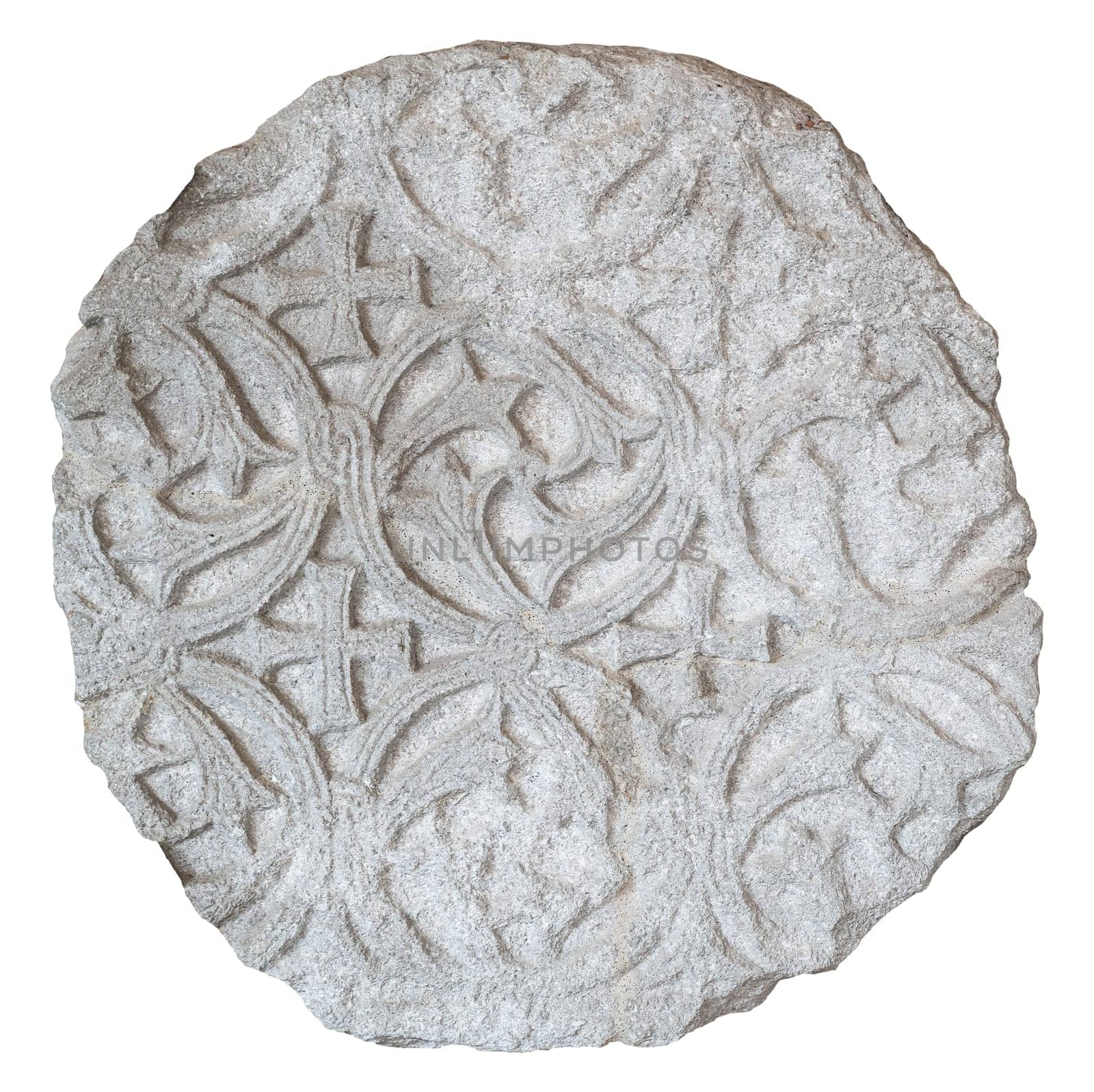 front view closeup of large round plaque of antique stone carved with floral pattern and ragged edges isolated on white