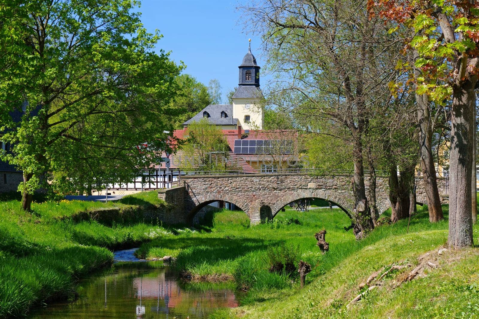the village of Rohma in Vogtland with church and bridge in spring, Germany