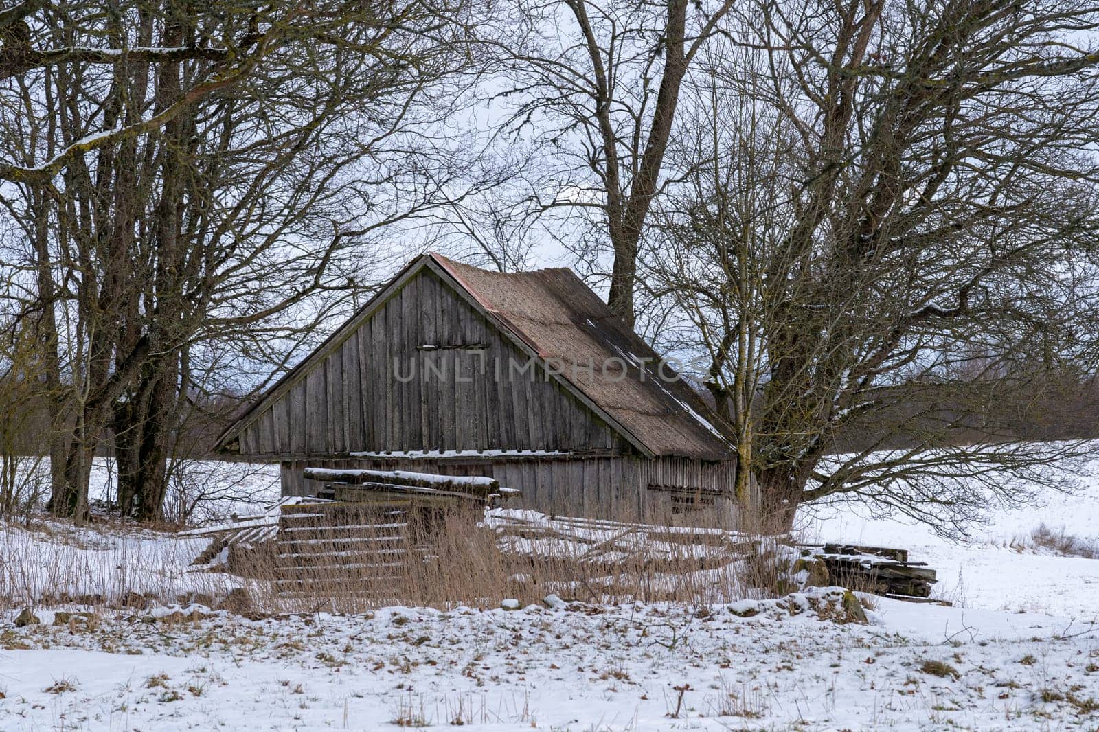 Old barn in the village on a winter day