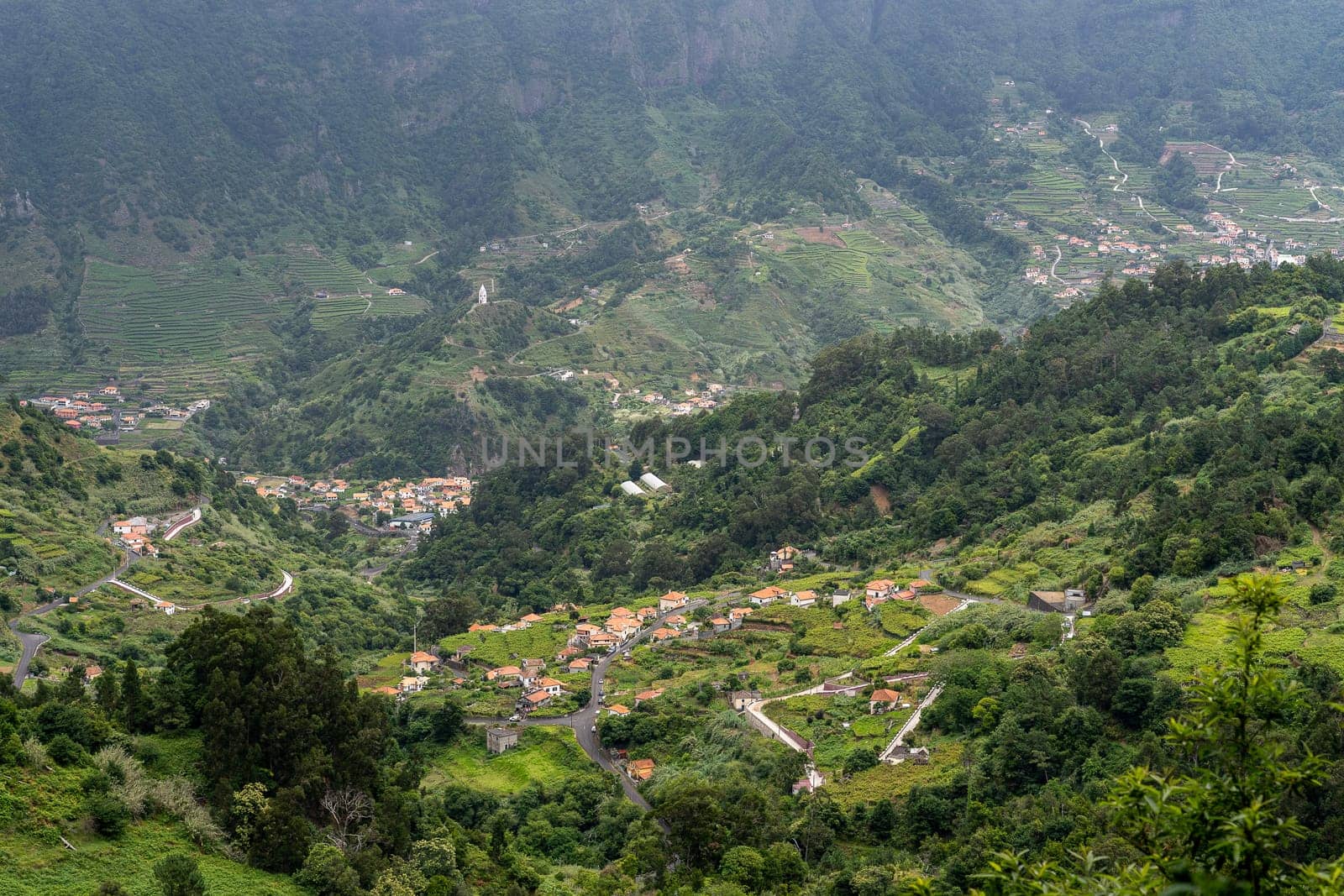 Aerial view on small city Sao Vicente - Chapel on the hill, huge mountains on background. Madeira island, Portugal.