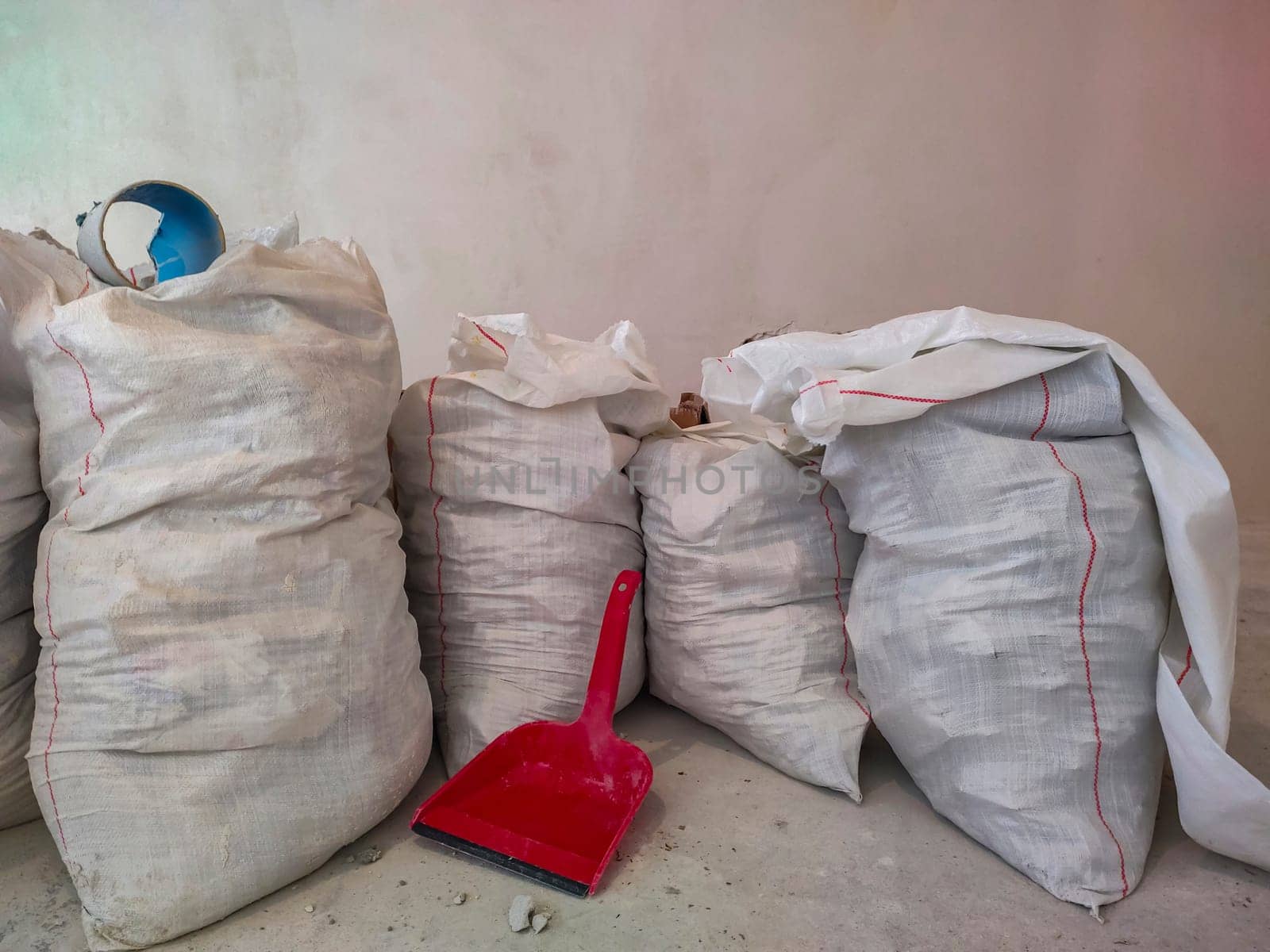 White polypropylene construction bags and scoop for garbage collection. Polypropylene bag. Construction waste. Repair of apartments. Industrial waste. Scoop for garbage collection.