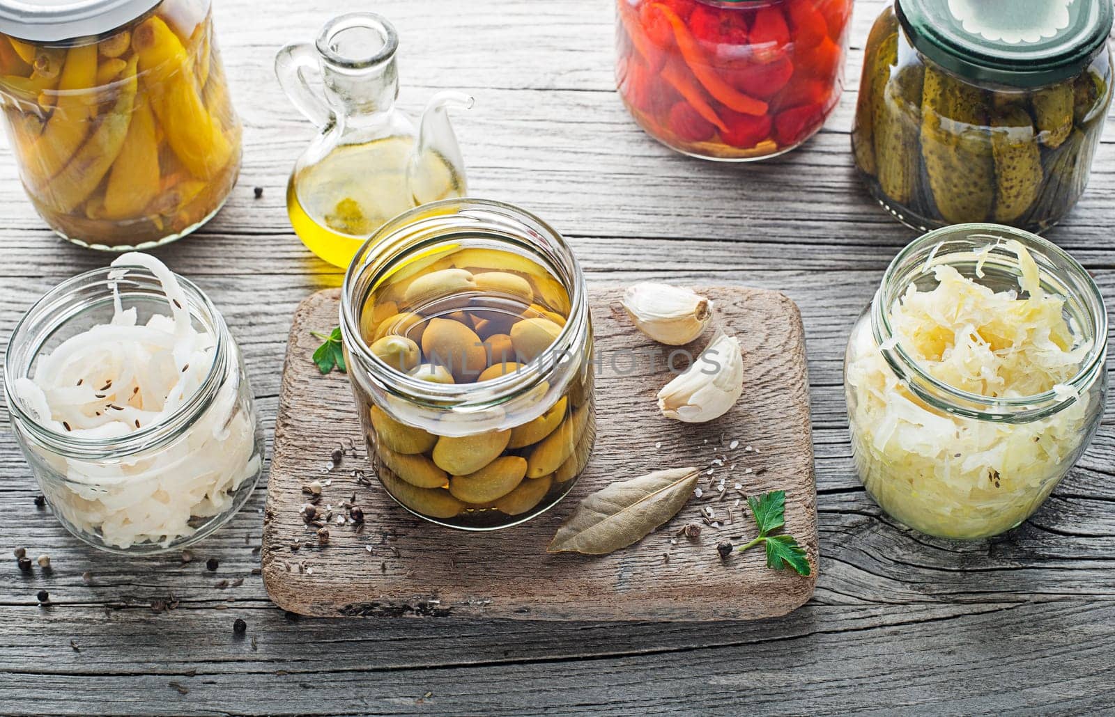 Canned and pickled vegetables in glass jars on wooden table. Preserved food