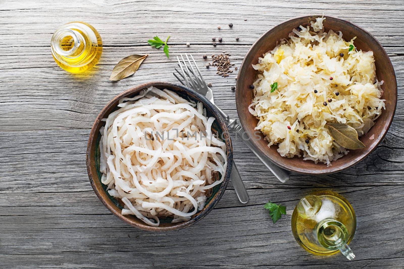 Traditional healthy sauerkraut and sour turnip on wooden background.