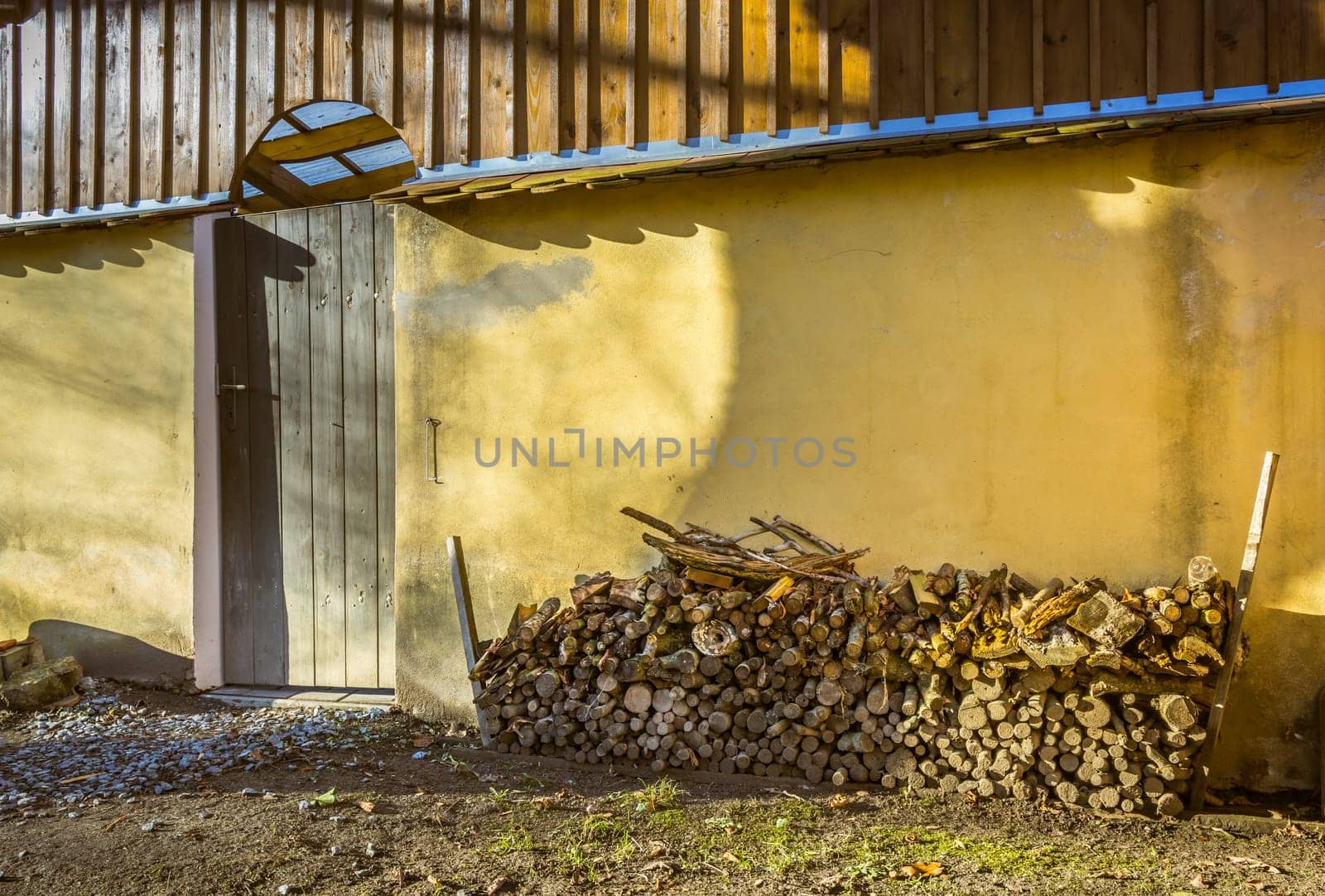 A pile of stacked firewood, prepared for heating the house, harvested for heating in winter on the house wall