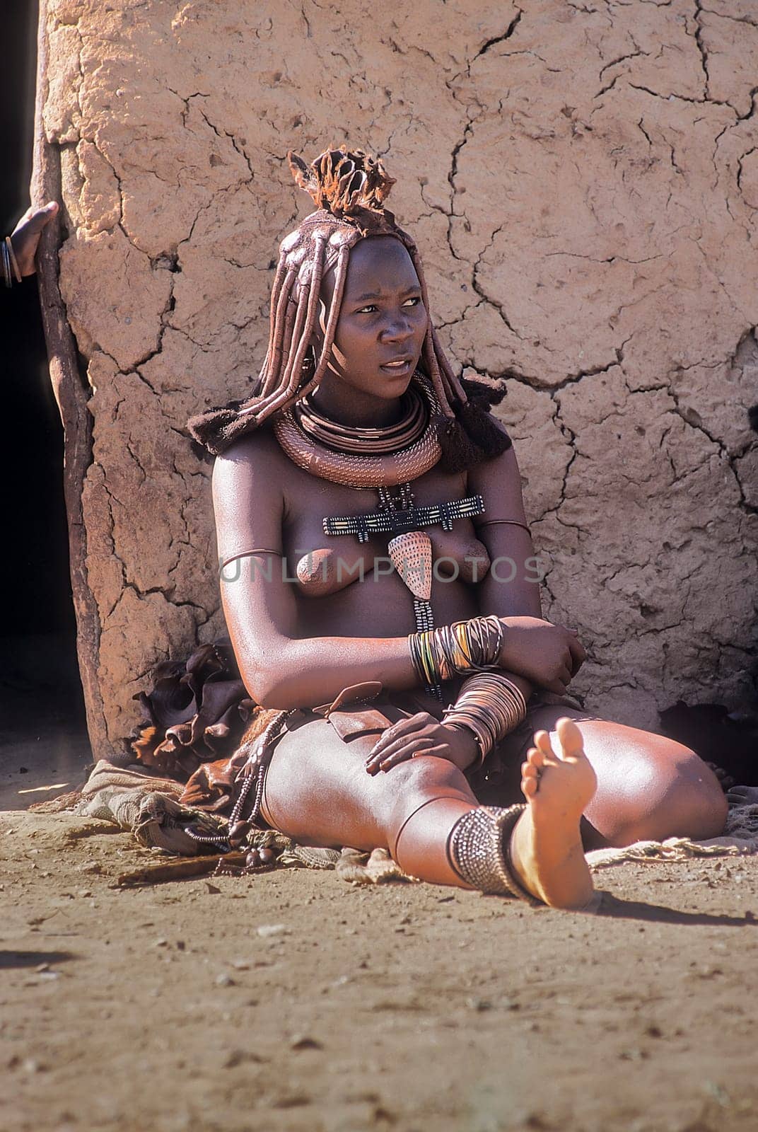 May 15, 2005. portrait of unidentified Himba woman  with the traditional hairstyle, necklace and the typical ochre tinted skin. Epupa Falls, Kaokoland or Kunene Province, Namibia, Africa