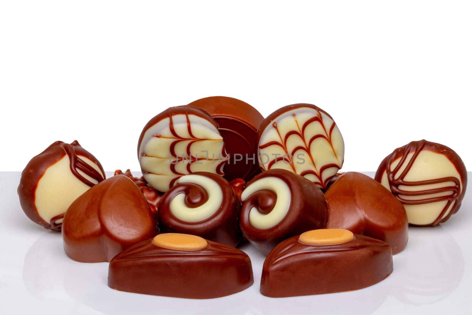Chocolate candies collection. Beautifully assortment of various swizz chocolate candies sweets on table isolated of a white background.