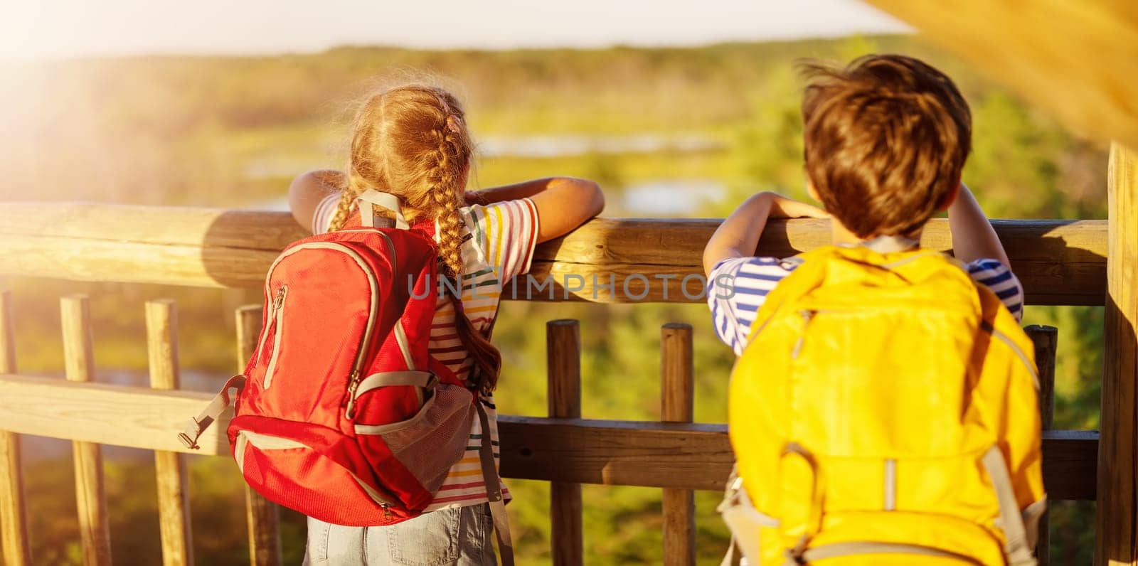 Girl and boy standing on the observation tower on the Viru bog. Concept of the family vacation and camping.