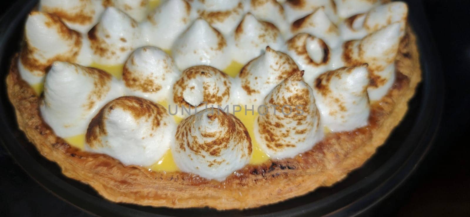 Lemon meringue pie over dark background. Selective focus