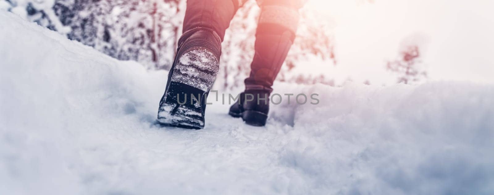 Woman walking in the snowy forest in winter. Concept of hiking and recreation.