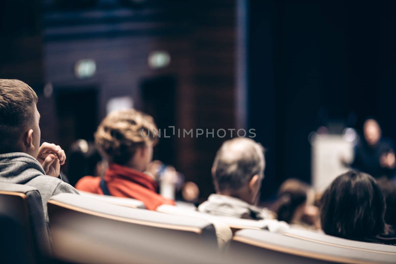 Speaker giving a talk in conference hall at business event. Rear view of unrecognizable people in audience at the conference hall. Business and entrepreneurship concept