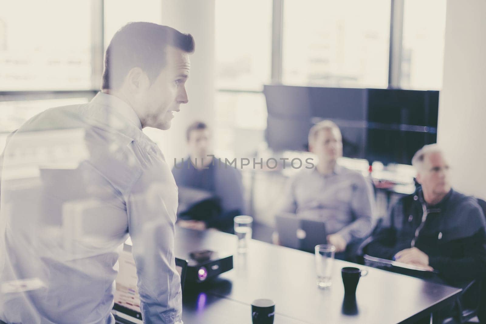 Business man making a presentation at office. Business executive delivering a presentation to his colleagues during meeting or in-house business training, explaining business plans to his employees.