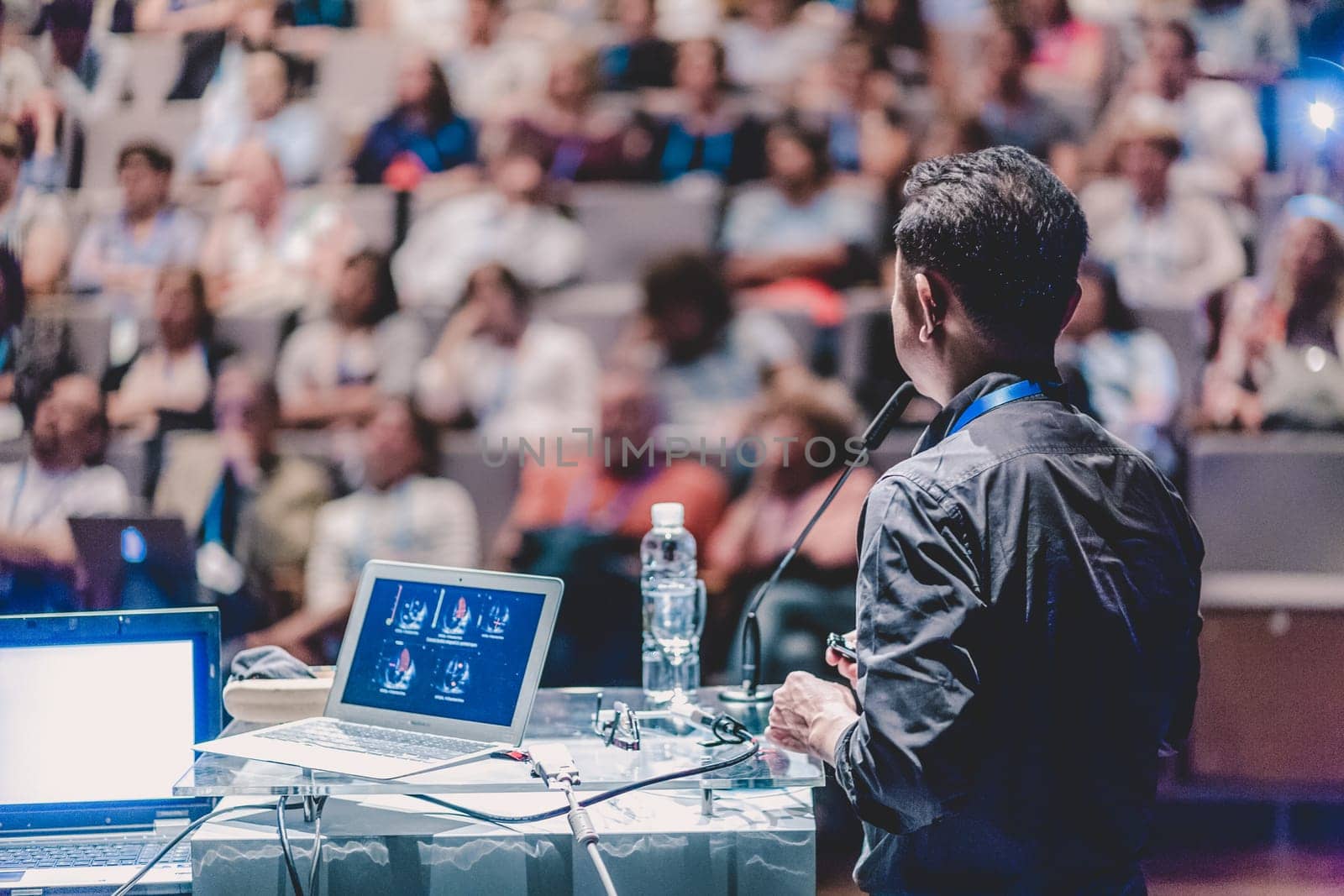 Speaker giving a talk on scientific conference. Audience at the conference hall. Business and Entrepreneurship event.