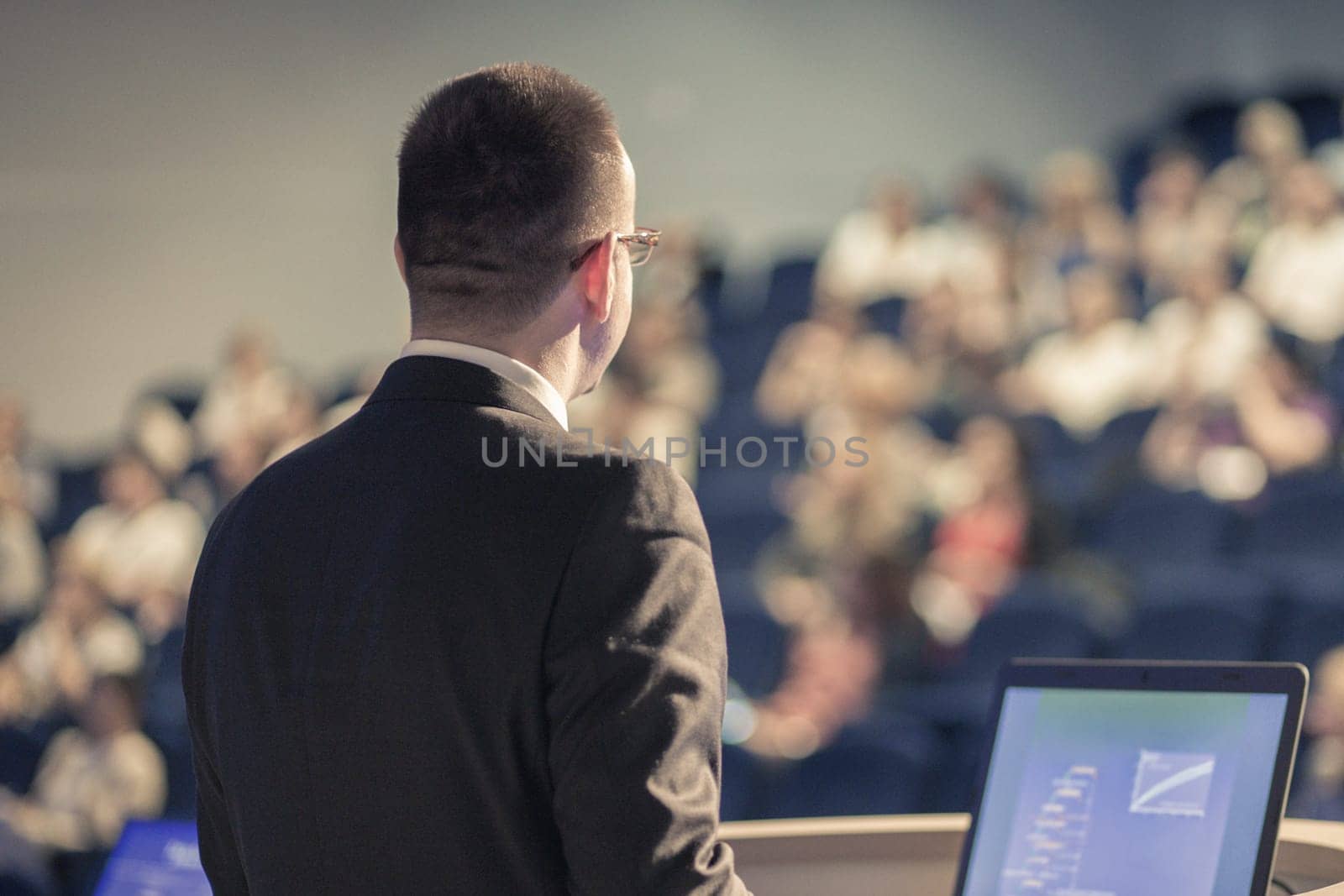 Speaker giving a talk on corporate Business Conference. Audience at the conference hall. Business and Entrepreneurship event.