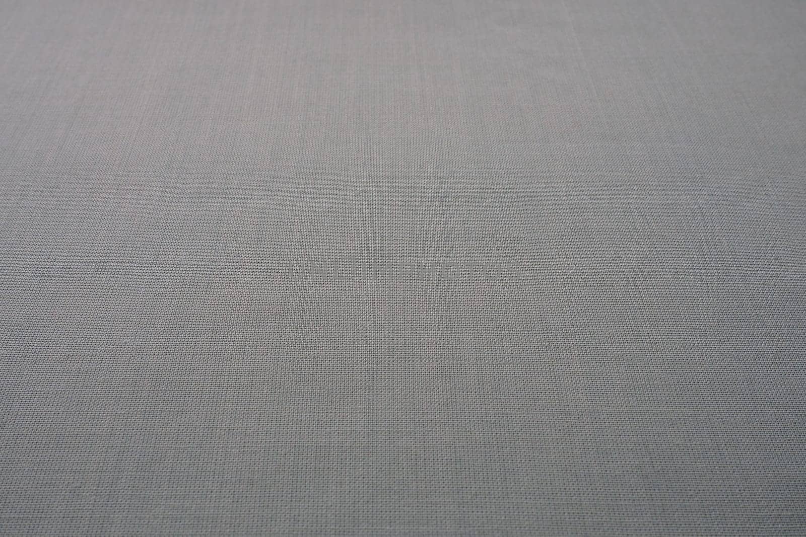 gray background fabric texture. A piece of woolen cloth is neatly laid out on the surface. Weave and textile texture. Dress fabric or for kitchen needs, tablecloth or curtains, close-up. Dash.