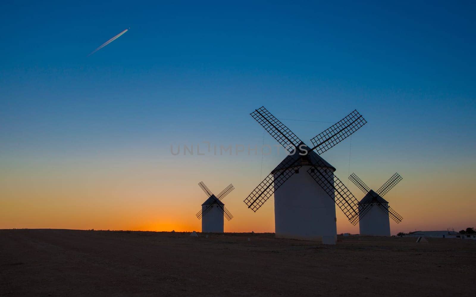 Airliner flying over old traditional windmills of Campo de Criptana, Castilla La Mancha (New Castile), Spain, Europe