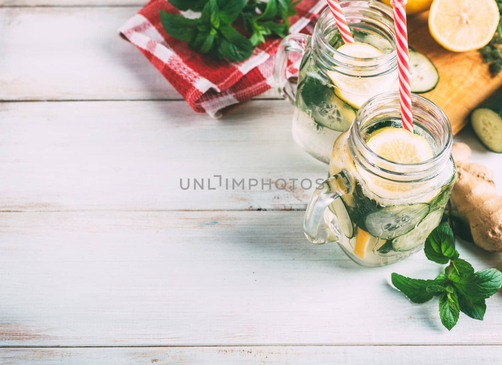 Homemade detox lemonade with cucumber, ginger and mint in retro mason jar glass on wooden table from above. Summer refreshment drink recipe. Healthy eating concept.