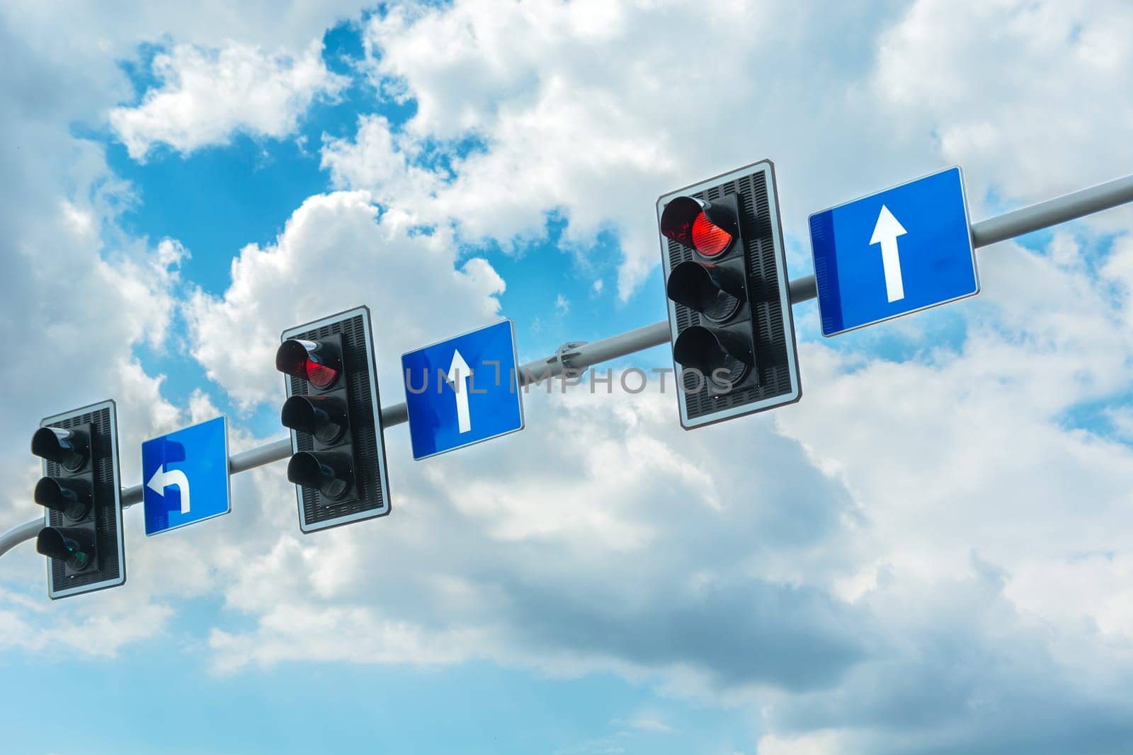 Traffic lights with a red light against the cloudy sky